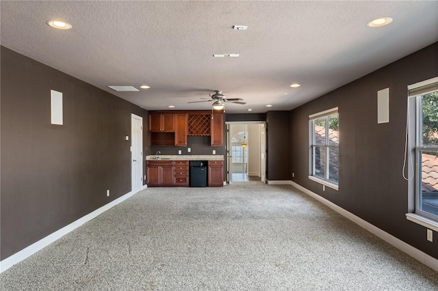 kitchen featuring dishwasher, carpet floors, sink, ceiling fan, and a textured ceiling