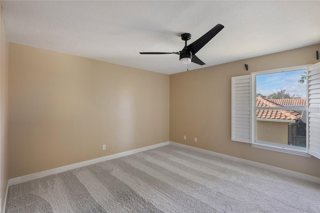 spare room featuring ceiling fan, light carpet, and a textured ceiling