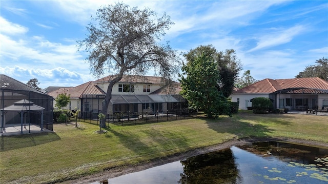 back of house featuring a yard and glass enclosure