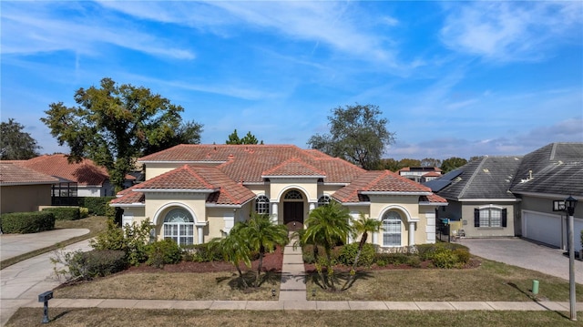 mediterranean / spanish home with a garage and a front yard