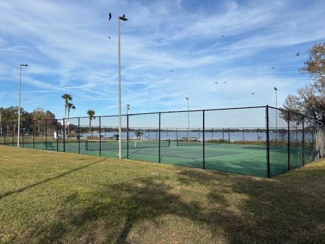 view of sport court featuring a lawn