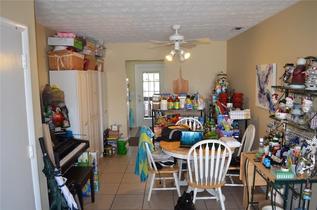 dining space with ceiling fan, tile patterned floors, and a textured ceiling