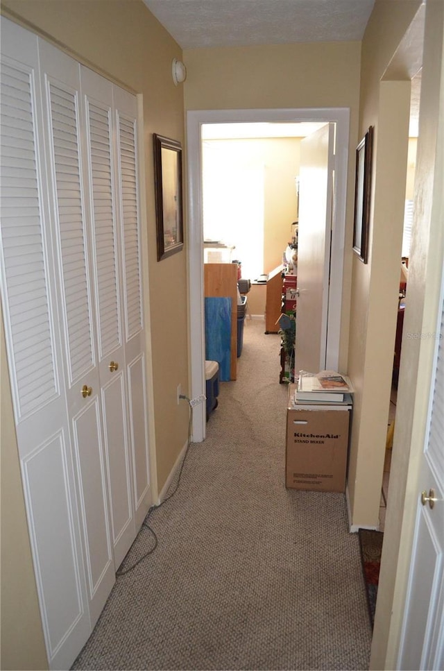 hallway with light colored carpet