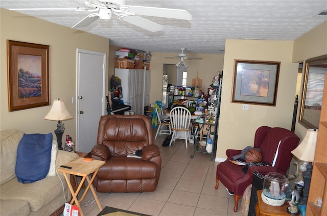 tiled living room with ceiling fan and a textured ceiling