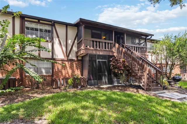 5413 Hansel Ave Unit K10, Orlando, FL 32809 - rear view of house featuring brick siding, stucco siding, stairs, and a sunroom