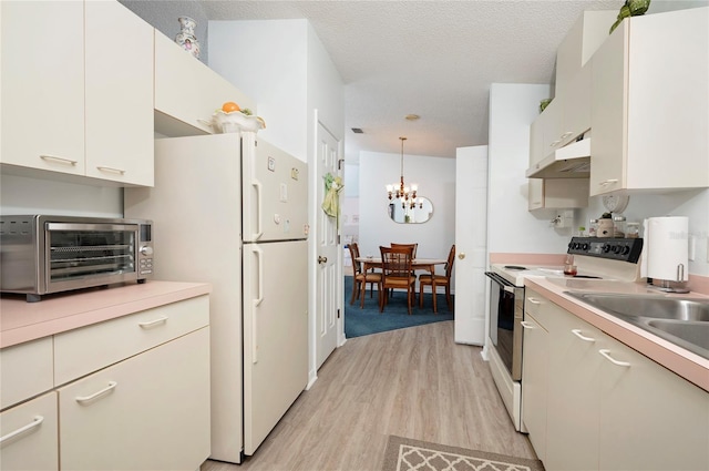 kitchen with white cabinetry, white appliances, hanging light fixtures, and light hardwood / wood-style flooring