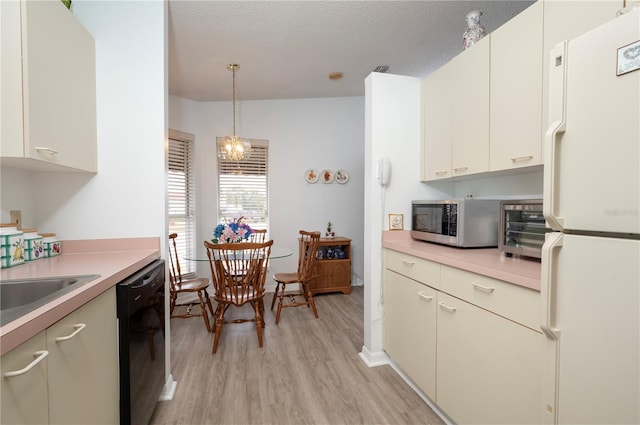 kitchen featuring a textured ceiling, hanging light fixtures, white refrigerator, light hardwood / wood-style flooring, and dishwasher