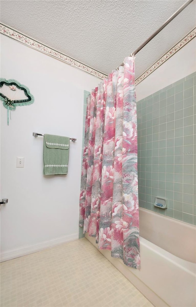 bathroom featuring shower / bath combination with curtain and a textured ceiling