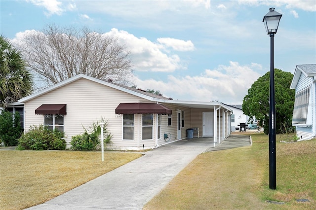 view of front of house with driveway, a front yard, and an attached carport