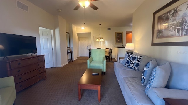8112 Poinciana Blvd, Orlando, FL 32821 - living room featuring baseboards, visible vents, dark carpet, and ceiling fan with notable chandelier