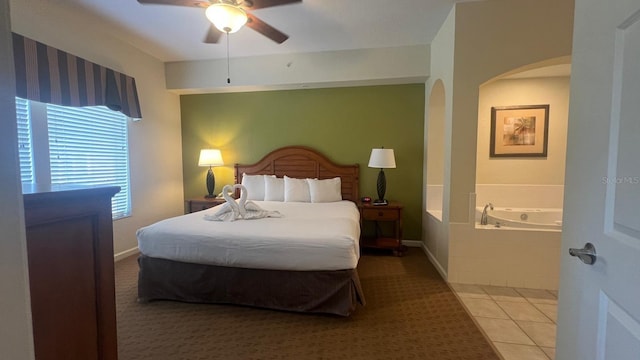 8112 Poinciana Blvd, Orlando, FL 32821 - bedroom with light tile patterned floors, ceiling fan, multiple windows, and arched walkways