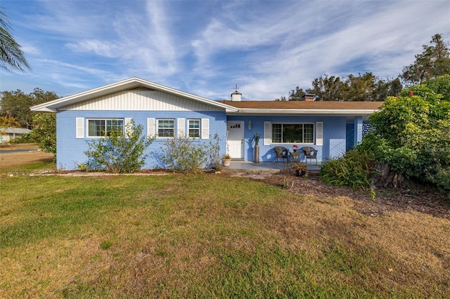 ranch-style house featuring a front yard and covered porch