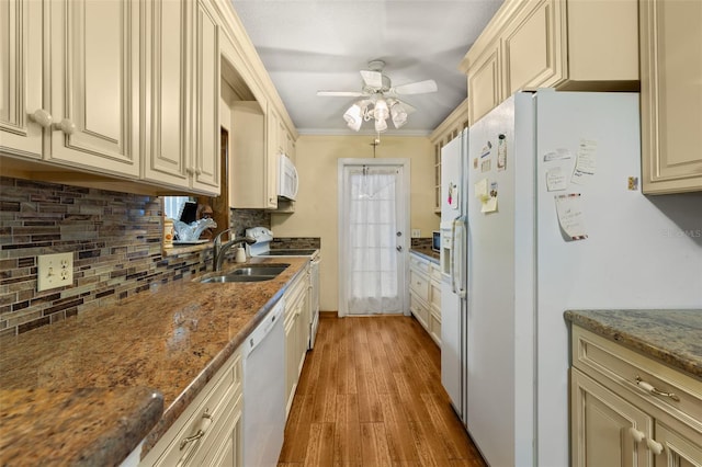 kitchen with sink, white appliances, and cream cabinetry