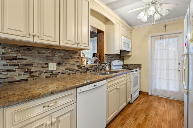 kitchen featuring sink, white appliances, dark stone countertops, tasteful backsplash, and ornamental molding