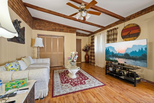 living room with vaulted ceiling with beams, hardwood / wood-style flooring, and ceiling fan