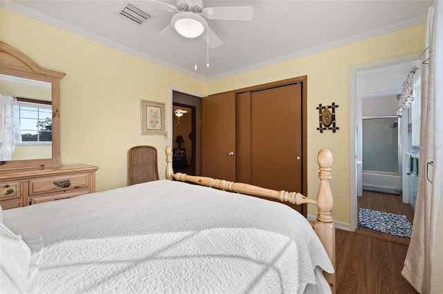 bedroom with crown molding, dark hardwood / wood-style flooring, and a closet