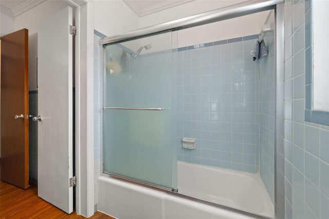 bathroom featuring wood-type flooring, ornamental molding, and shower / bath combination with glass door