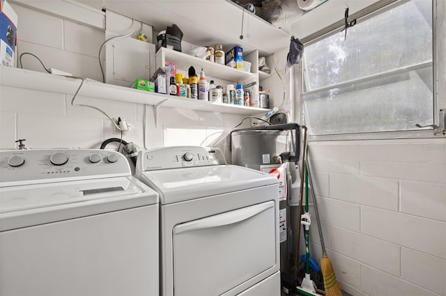 clothes washing area with washing machine and clothes dryer and water heater