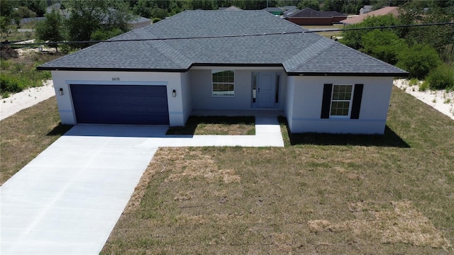 ranch-style home with roof with shingles, an attached garage, concrete driveway, and stucco siding