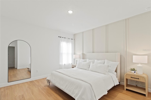 bedroom with light wood-style floors, baseboards, and recessed lighting