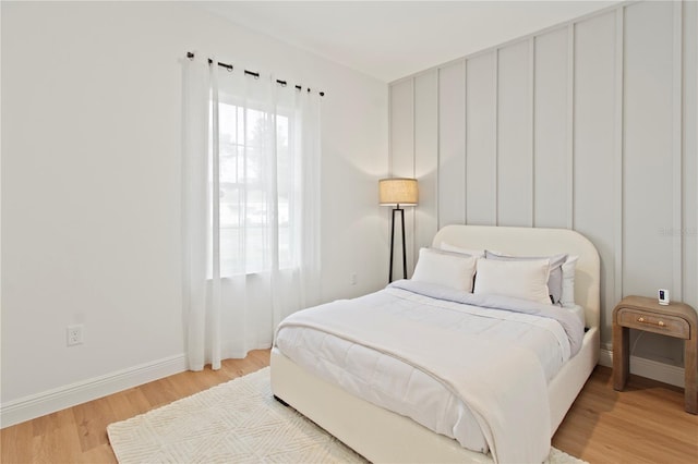 bedroom with light wood-style floors and baseboards