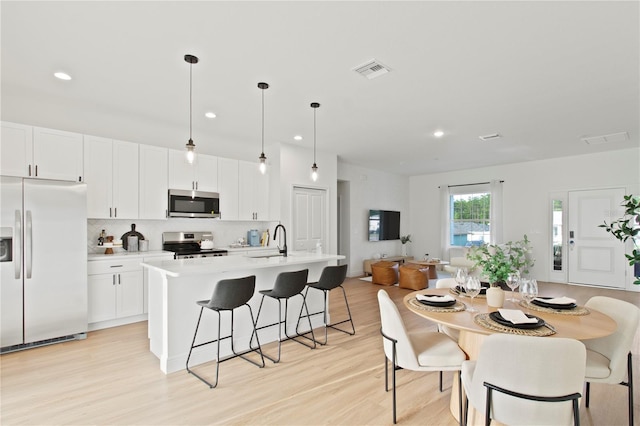 dining room with light wood-style floors and recessed lighting