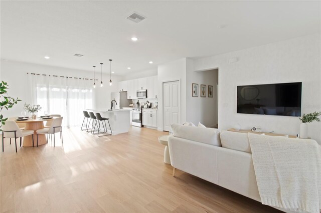 living room featuring light wood finished floors and recessed lighting