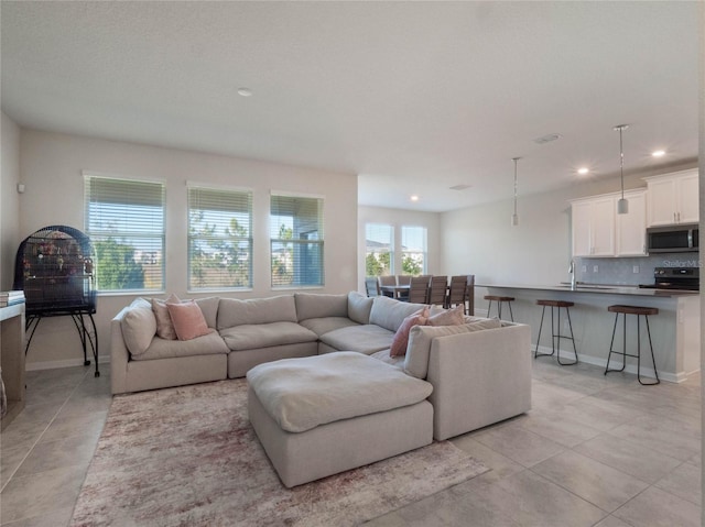 living room with sink and light tile patterned floors