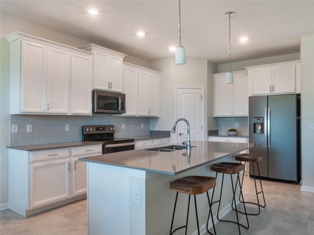 kitchen featuring a kitchen island with sink, sink, white cabinetry, and stainless steel appliances