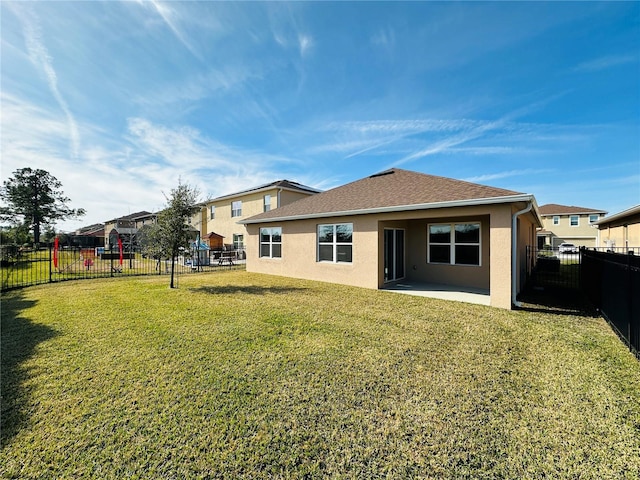 rear view of property with a lawn and a patio area