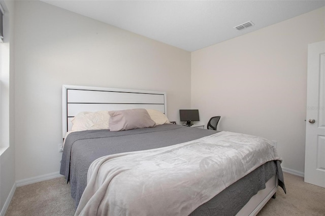 bedroom featuring visible vents, light carpet, and baseboards