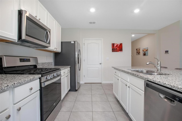 kitchen with a sink, visible vents, white cabinetry, appliances with stainless steel finishes, and light stone countertops