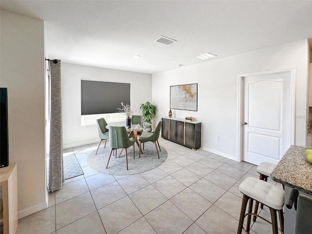 dining space with visible vents, baseboards, and light tile patterned floors