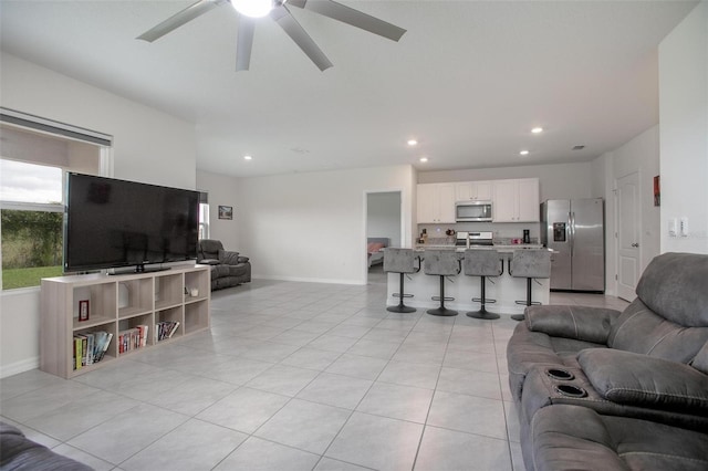 living area featuring a ceiling fan, recessed lighting, light tile patterned flooring, and baseboards