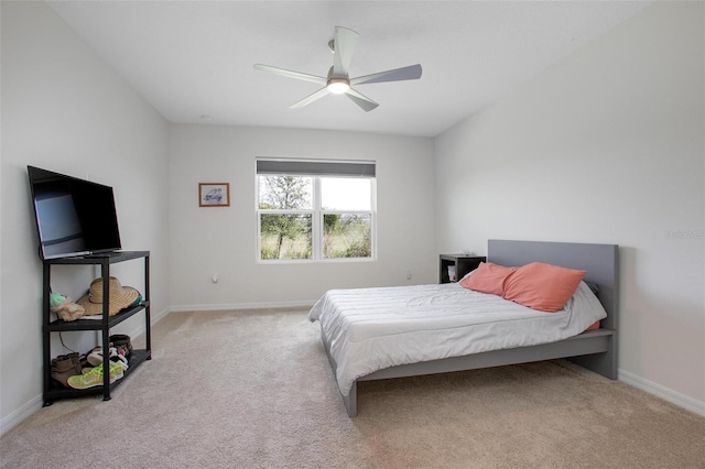 bedroom featuring light carpet, ceiling fan, and baseboards