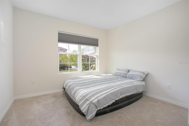 bedroom with light carpet and baseboards