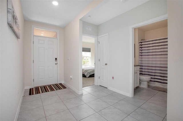 entryway with baseboards and light tile patterned flooring