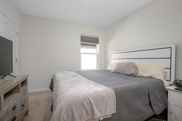 bedroom with light carpet and baseboards