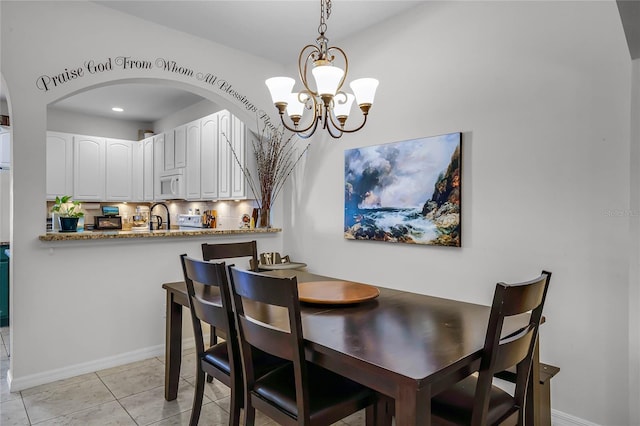 tiled dining space featuring an inviting chandelier and sink