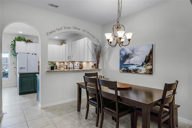 dining area featuring a chandelier, sink, and light tile patterned floors