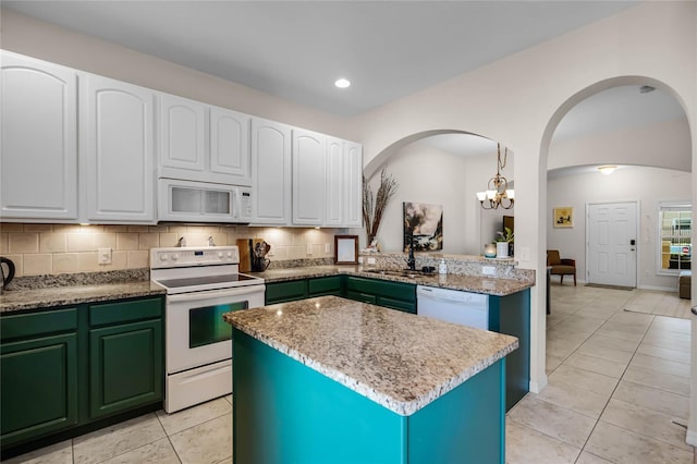 kitchen featuring a kitchen island, white cabinets, white appliances, and decorative backsplash