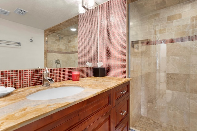 bathroom featuring walk in shower, vanity, and tasteful backsplash