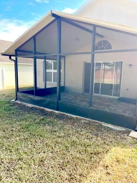 view of home's exterior featuring a yard and a sunroom