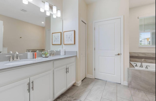 bathroom featuring vanity, tiled tub, and tile patterned floors