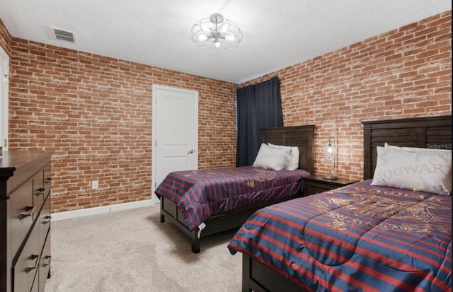 bedroom featuring light colored carpet, brick wall, and a textured ceiling