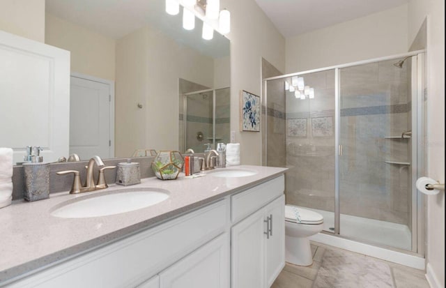 bathroom featuring vanity, toilet, and a shower with shower door