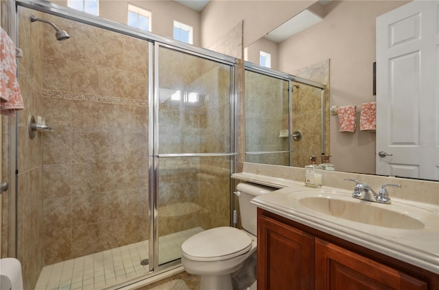 bathroom featuring vanity, a wealth of natural light, an enclosed shower, and toilet