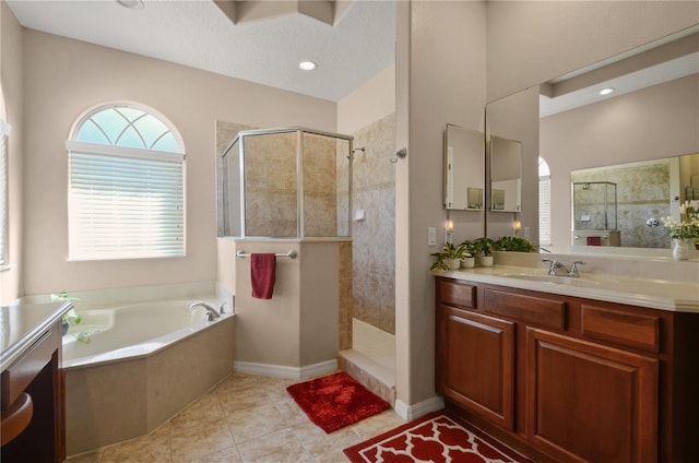 bathroom featuring tile patterned flooring, vanity, separate shower and tub, and a textured ceiling