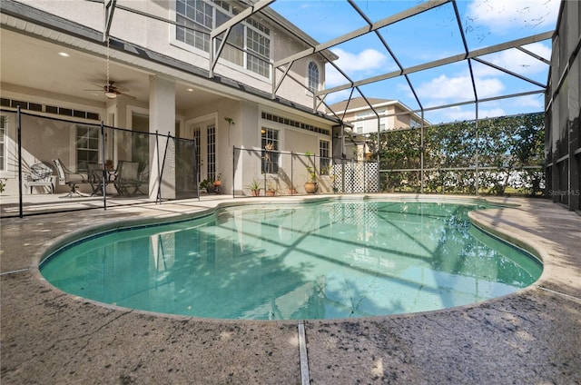 view of pool featuring a patio area, ceiling fan, and glass enclosure