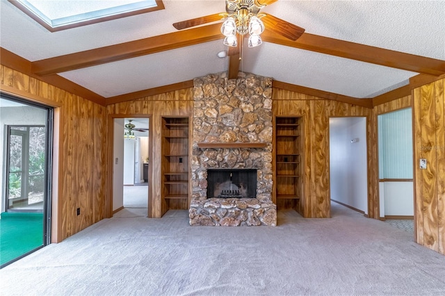 unfurnished living room featuring carpet, a textured ceiling, and wood walls